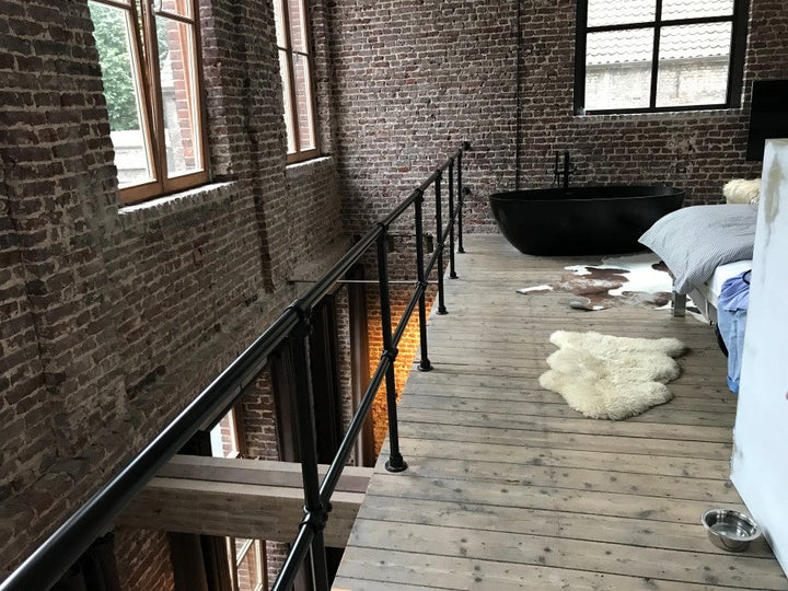Modernes schwarzes Geländer mit Rohrverbindern in einem Loft – stilvolle Sicherheitslösung für den Innenbereich